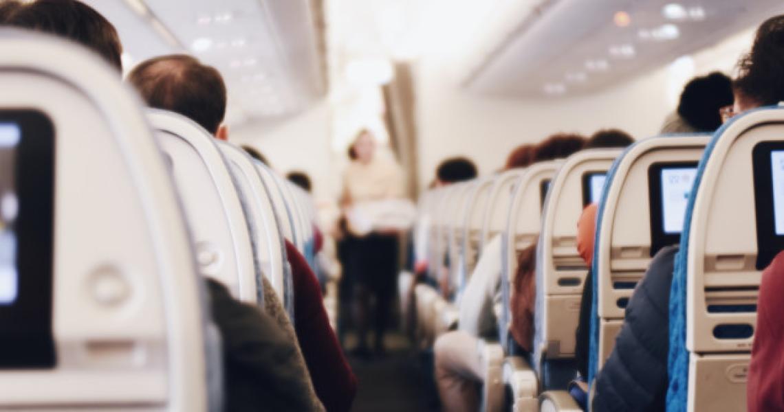 Aisle seats full of passengers on a plane.