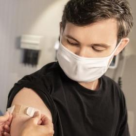 A white man receiving a vaccine from a nurse.